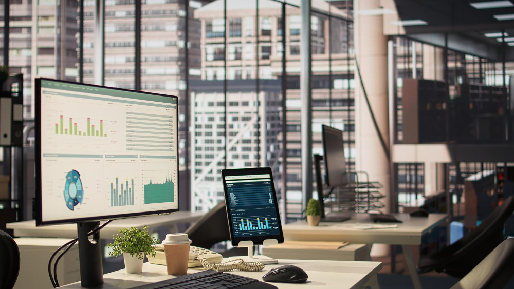 Desktop monitors displaying live sales and inventory dashboards in a modern office